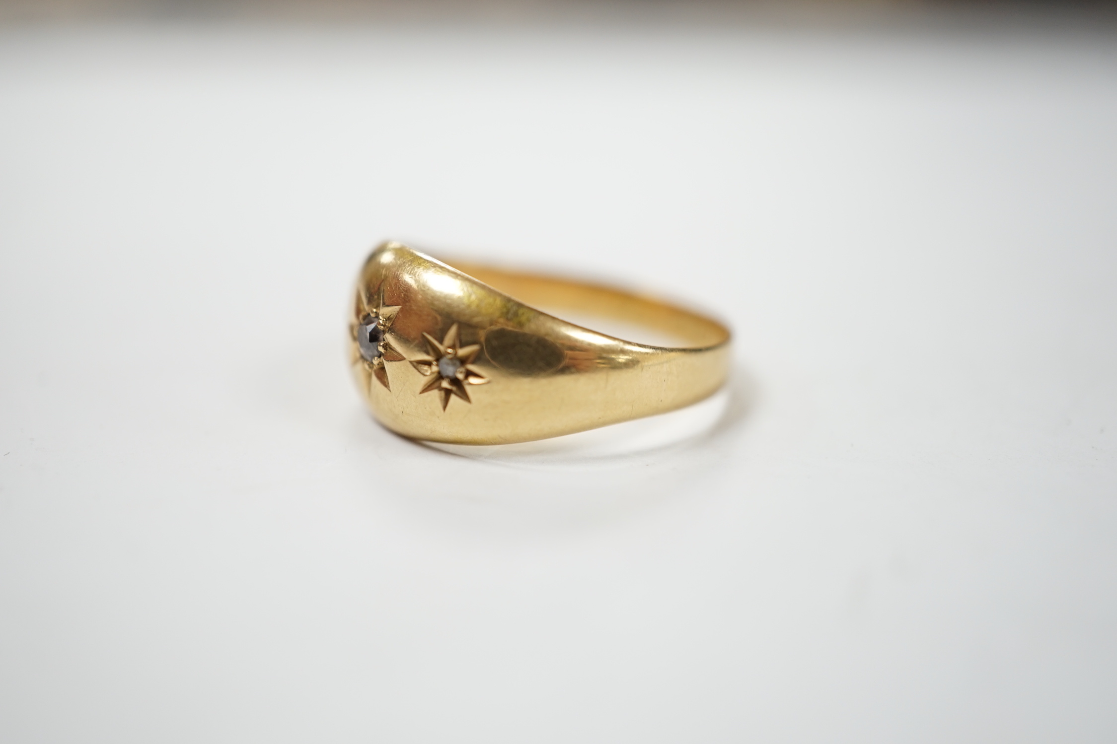 A George V 18ct gold and three stone gypsy set diamond chip set ring, size R, gross weight 3.3 grams.